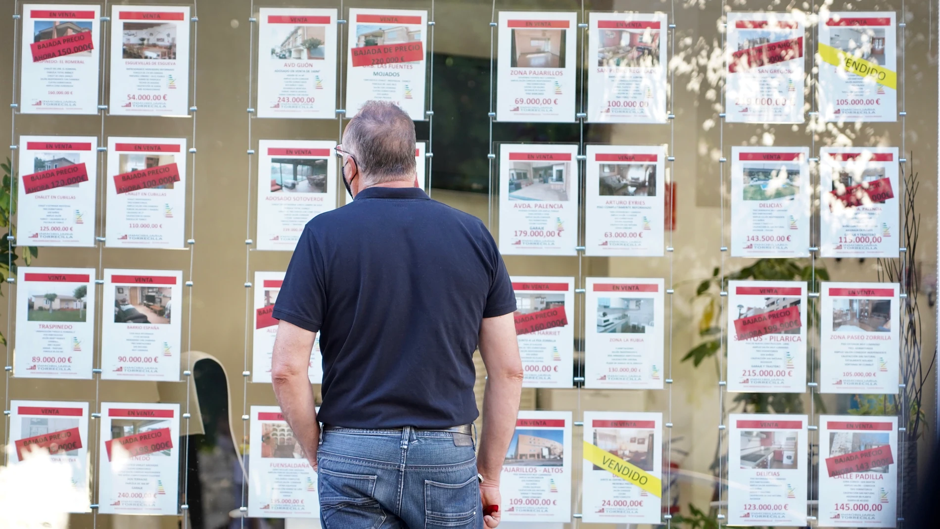 Una persona observa los precios de viviendas de una inmobiliaria