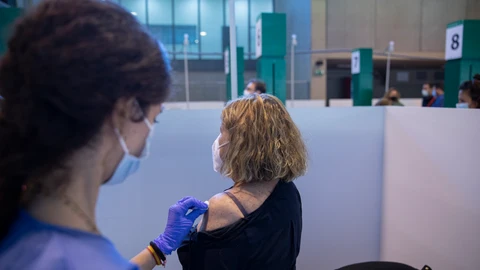 Una sanitaria vacuna a una mujer en Sevilla