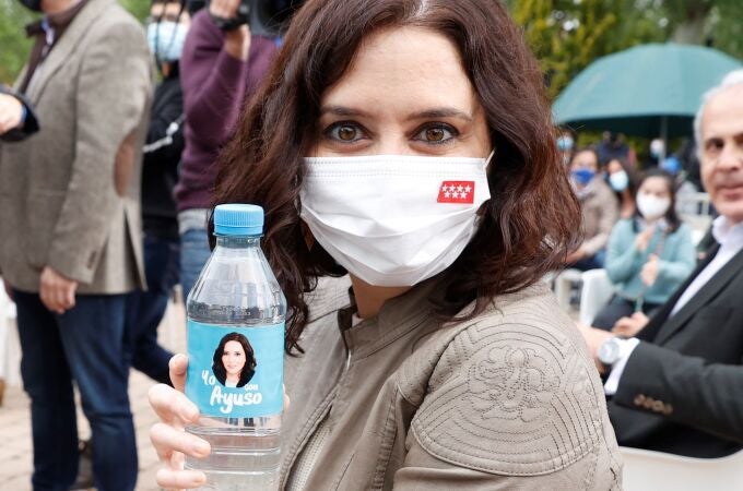 La presidenta de la Comunidad de Madrid y candidata a la reelección, Isabel Díaz Ayuso, posa con una botella de agua con su cara impresa durante un acto de campaña celebrado este sábado en Pozuelo de Alarcón.