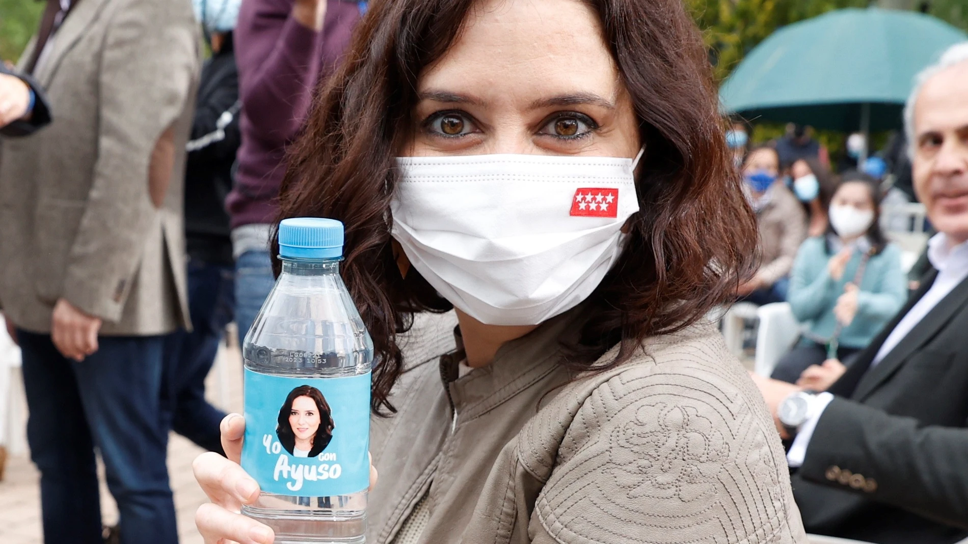 La presidenta de la Comunidad de Madrid y candidata a la reelección, Isabel Díaz Ayuso, posa con una botella de agua con su cara impresa durante un acto de campaña celebrado este sábado en Pozuelo de Alarcón.
