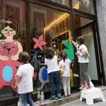Los niños, junto a artistas urbanos, realizan intervenciones artísticas en los escaparates de Malasaña