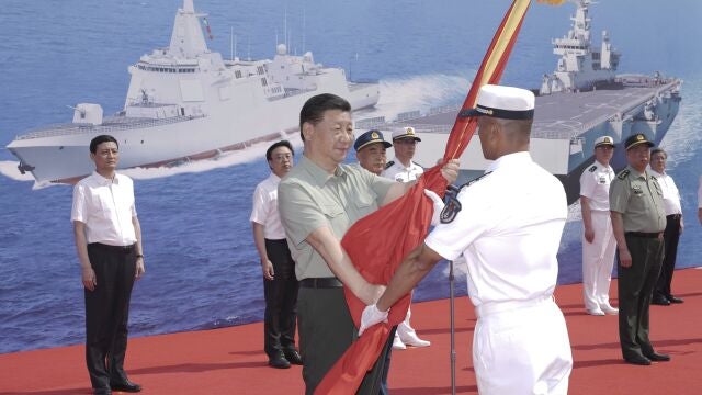 El presidente chino, Xi Jinping, presenta una bandera del Ejército Popular de Liberación (EPL) en la provincia de Hainan, sur de China