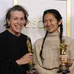 Frances McDormand (izq.) y Chloé Zhao posan con dos de los tres Oscar que ha ganado &quot;Nomadland&quot;, la gran triunfadora de la noche.