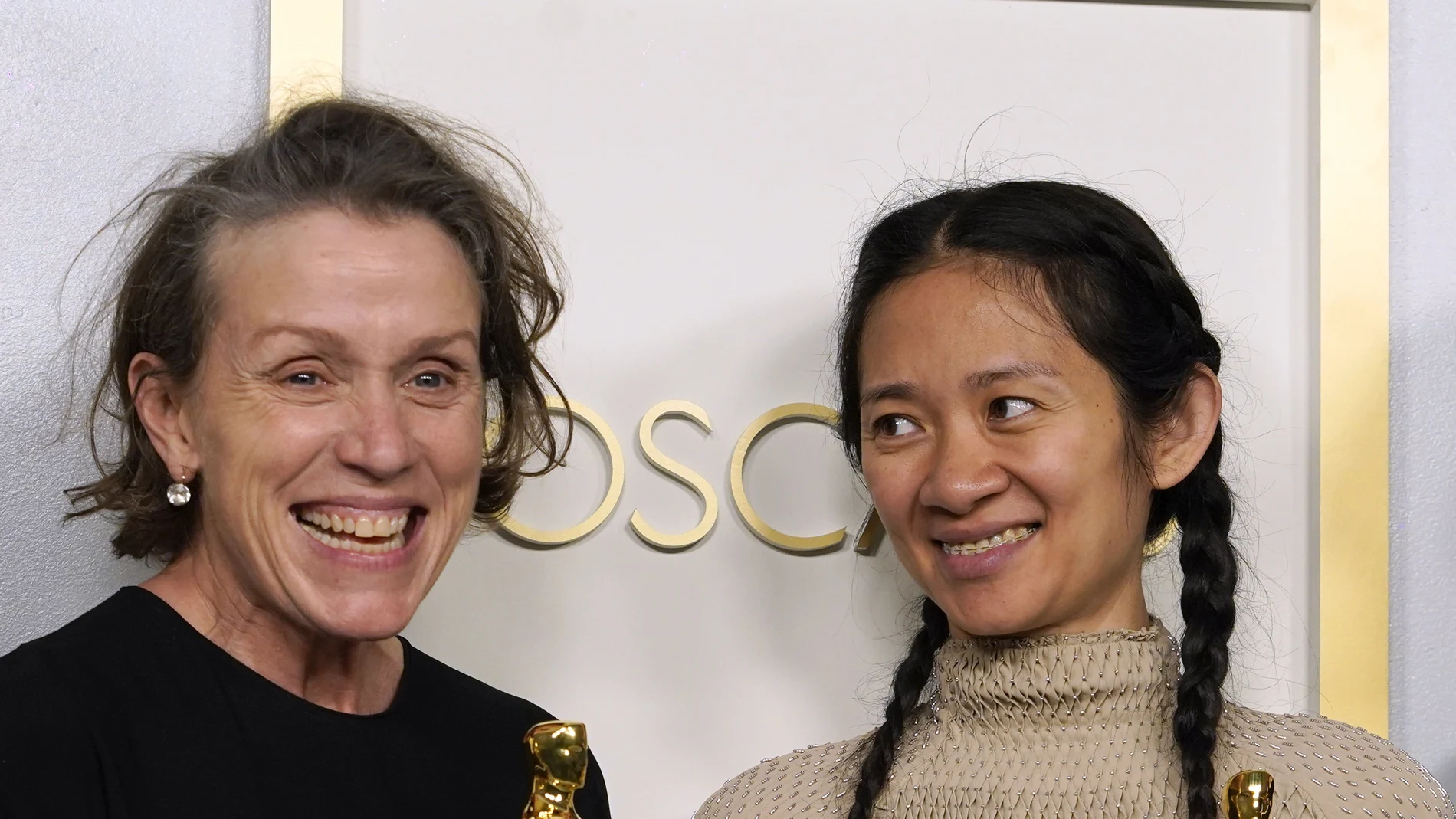 Frances McDormand (izq.) y Chloé Zhao posan con dos de los tres Oscar que ha ganado "Nomadland", la gran triunfadora de la noche.