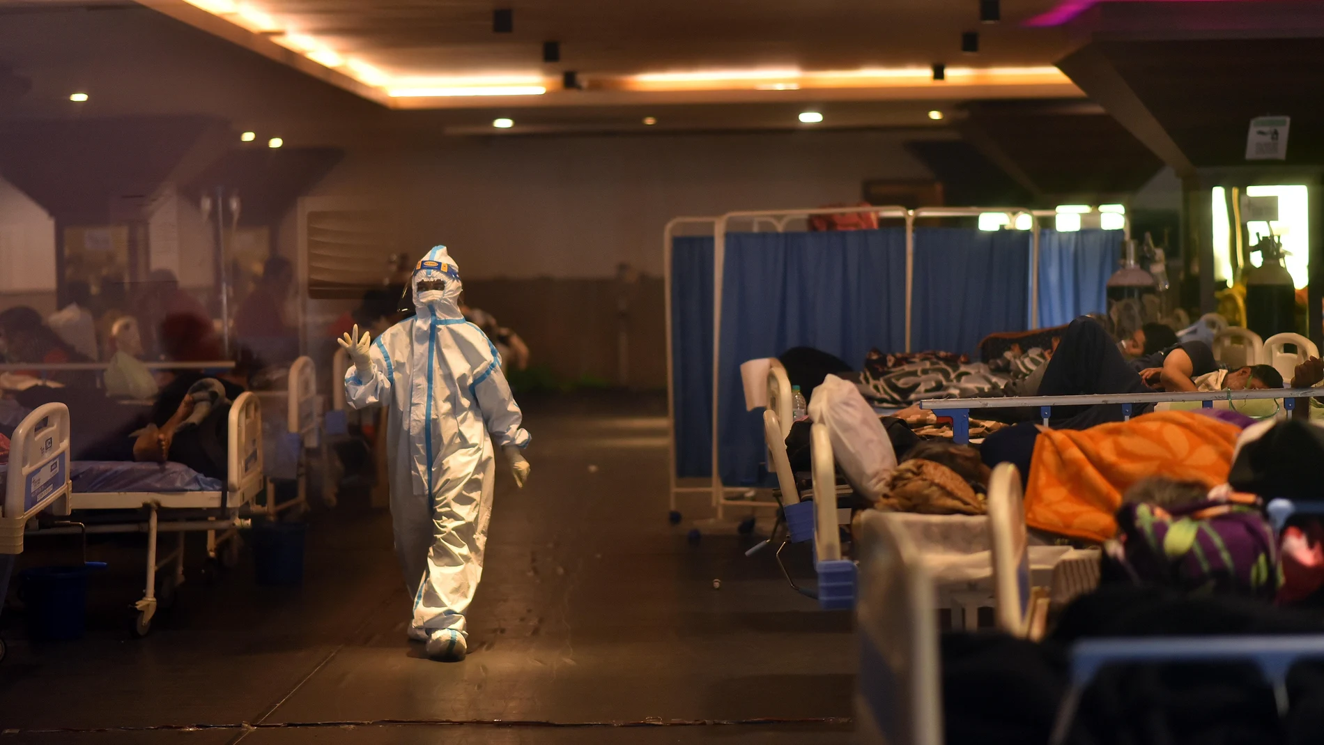 Un médico examina a los pacientes contagiados con covid-19 en una instalación especial cerca de uno de los hospitales de Nueva Delhi