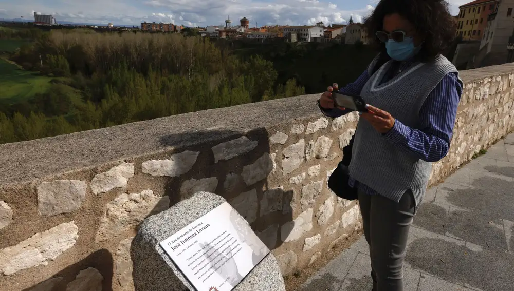 Una mujer observa la placa homenaje a Jiménez Lozano