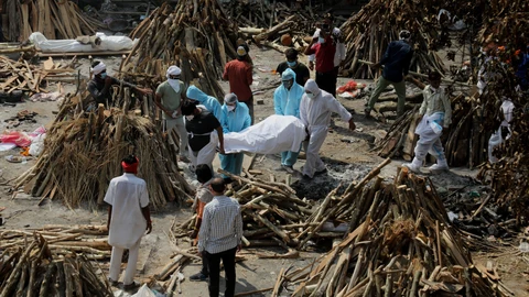 GRAPHICS - 26 April 2021, India, New Delhi: People wearing personal protective equipment carry the body of a relative who died from the COVID-19 disease, before cremation at Ghazipur cremation ground in New Delhi. India saw a new global record of 352,991 daily new Covid-19 infections and 2,812 Covid-19 deaths on Monday as a second wave of the pandemic overwhelmed health systems. Photo: Naveen Sharma/SOPA Images via ZUMA Wire/dpa - ATTENTION: graphic contentNaveen Sharma/SOPA Images via ZU / DPA26/04/2021 ONLY FOR USE IN SPAIN