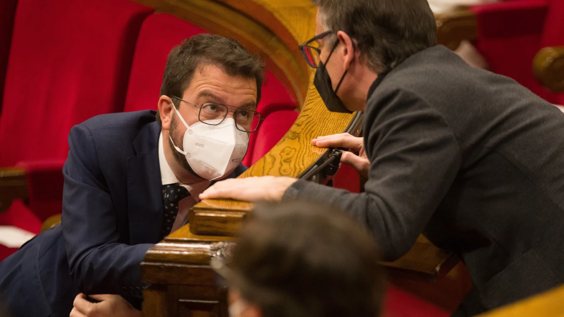 El vicepresidente de la Generalitat en funciones y candidato a la presidencia por ERC, Pere Aragonès, conversa con su compañero de partido Josep Maria Jové (d), en el pleno del Parlament.