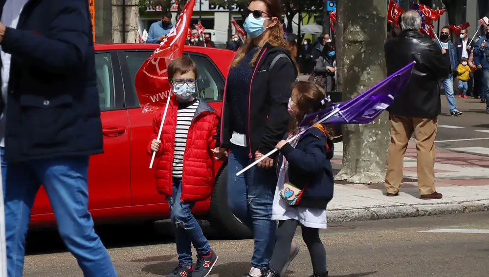 Una madre con sus dos hijos acude a la concentración del 1 de mayo en León