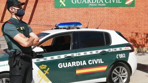 Un agente de la Guardia Civil, junto a un vehículo del cuerpo