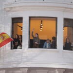 Un grupo de madrileñas ondea la bandera de España desde un balcón de la calle Génova