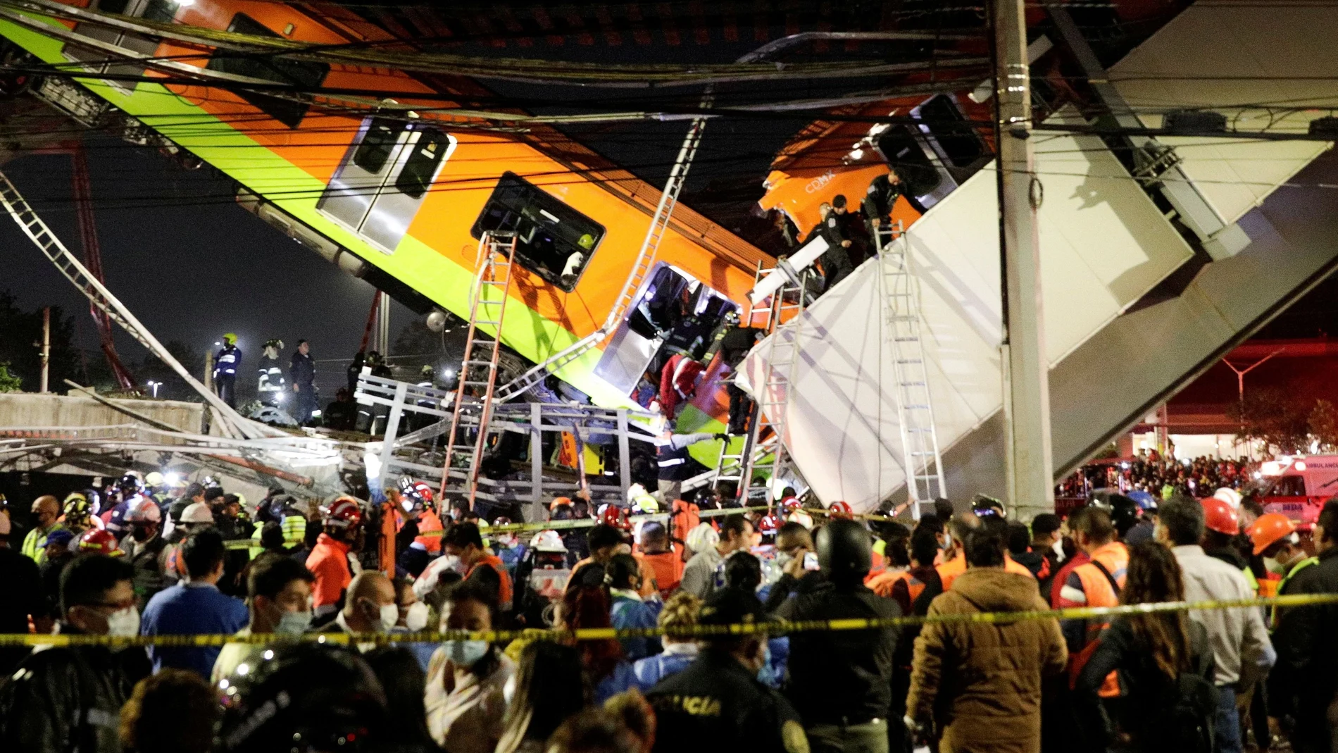 Servicios de emergencia trabajan en un sitio donde un paso elevado de un metro colapsó parcialmente con vagones de tren en la estación de Olivos en la Ciudad de México