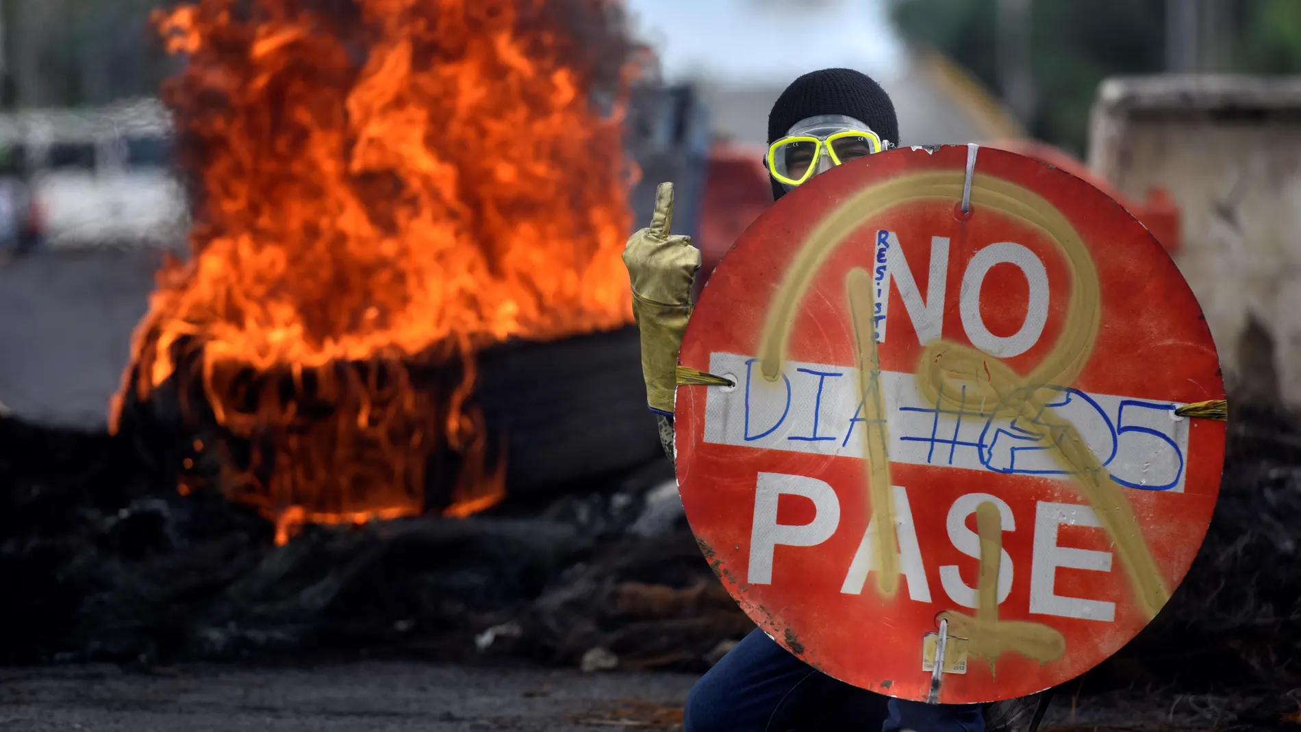 Un manifestante sostiene un aviso durante una protesta hoy en Cali (Colombia)