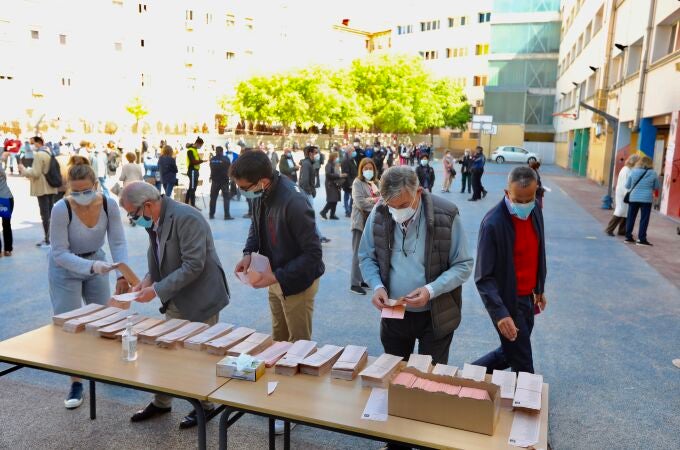 Varios ciudadanos cogen la papeleta en un colegio de Madrid