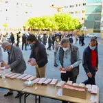 Varios ciudadanos cogen la papeleta en un colegio de Madrid