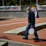 Un hombre camina con las bolsas de la compra por la "Plaza Roja" de Vallecas