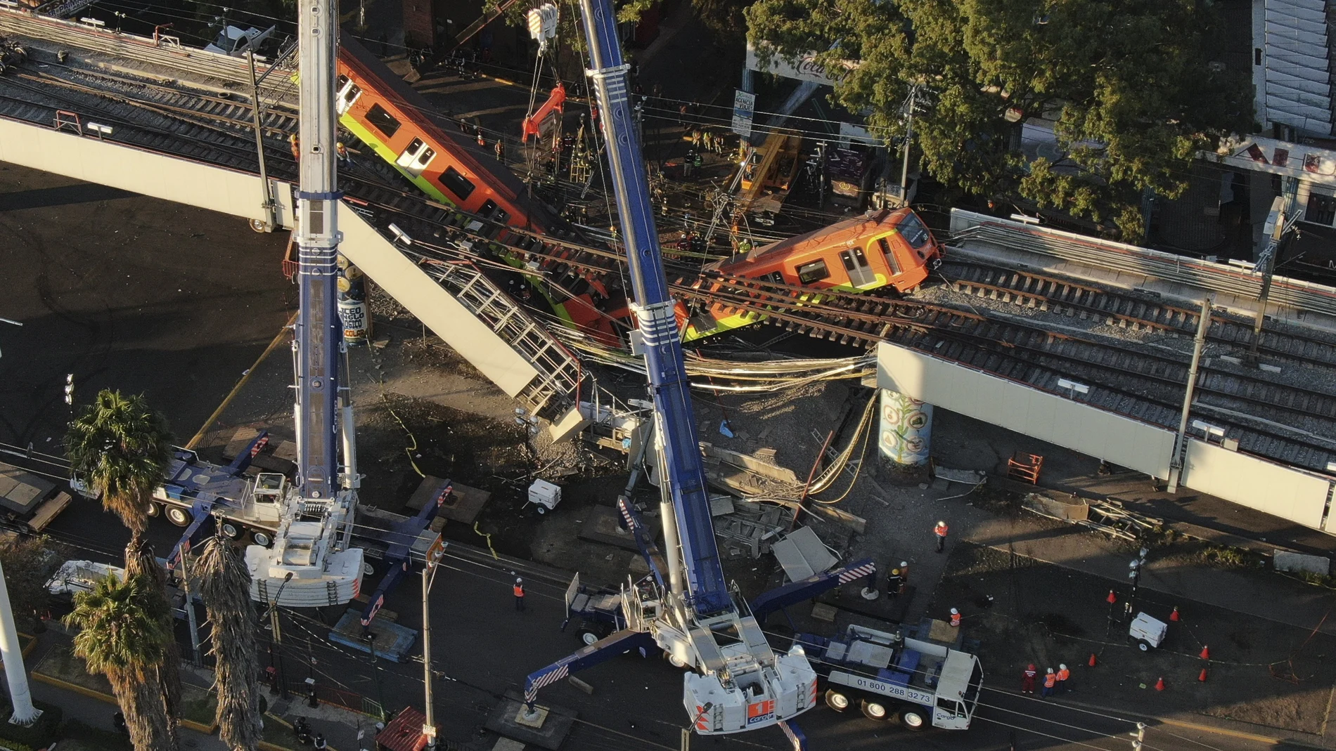 An aerial view of subway cars dangle at an angle from a collapsed elevated section of the metro, in Mexico City, Tuesday, May 4, 2021. The elevated section of Mexico City's metro collapsed late Monday killing at least 23 people and injuring at least 79, city officials said. (AP Photo/Fernando Llano)