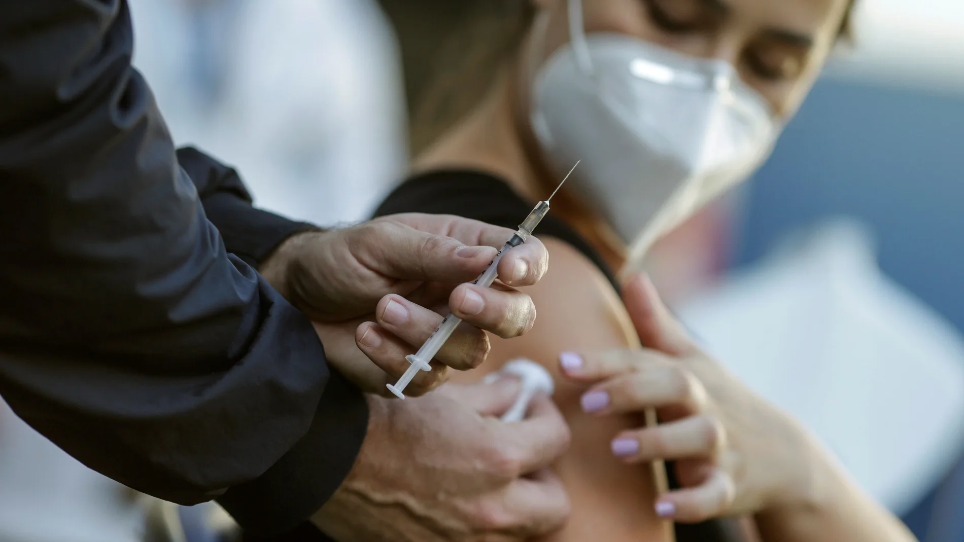Una mujer que lleva una máscara protectora, fotografiada después de recibir una dosis de la vacuna de Pfizer/BioNTech contra la covid-19.. EFE/André Coelho