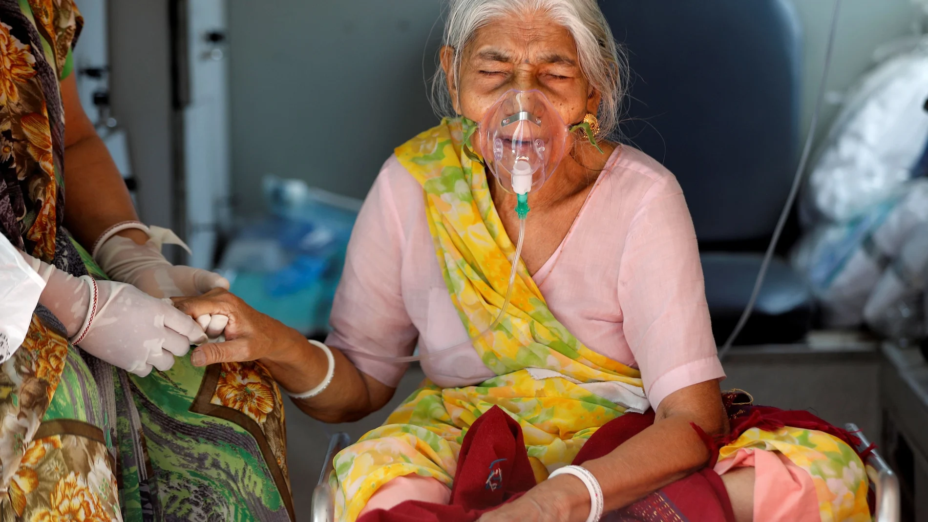 Lilaben Gautambhai Modi, de 80 años, con una máscara de oxígeno, sentada dentro de una ambulancia mientras espera ingresar a un hospital, en Ahmedabad