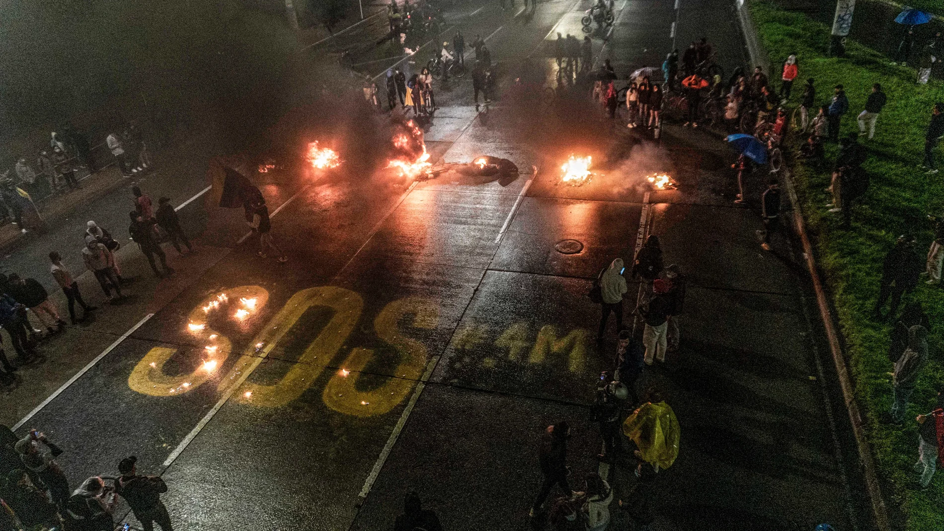 04 May 2021, Colombia, Bogota: Protesters write 'SOS' on the street during a protest as part of a national strike against the government's tax reform bill. Photo: Daniel Garzon Herazo/ZUMA Wire/dpaDaniel Garzon Herazo/ZUMA Wire/d / DPA04/05/2021 ONLY FOR USE IN SPAIN
