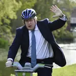 El &quot;premier británico&quot;, Boris Johnson saluda sobre una bicicleta