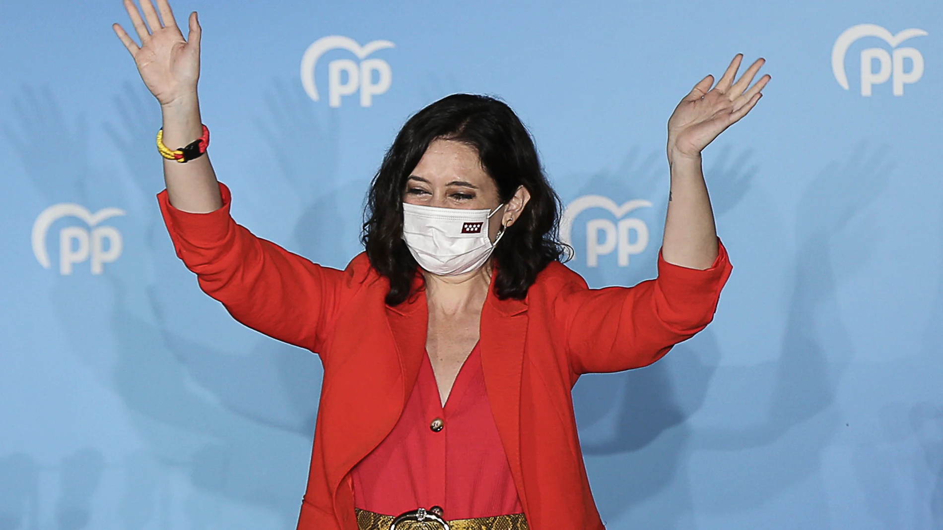 La presidenta de la Comunidad de Madrid y candidata a la reelección por el PP, Isabel Díaz Ayuso, saluda desde el balcón de la sede del partido