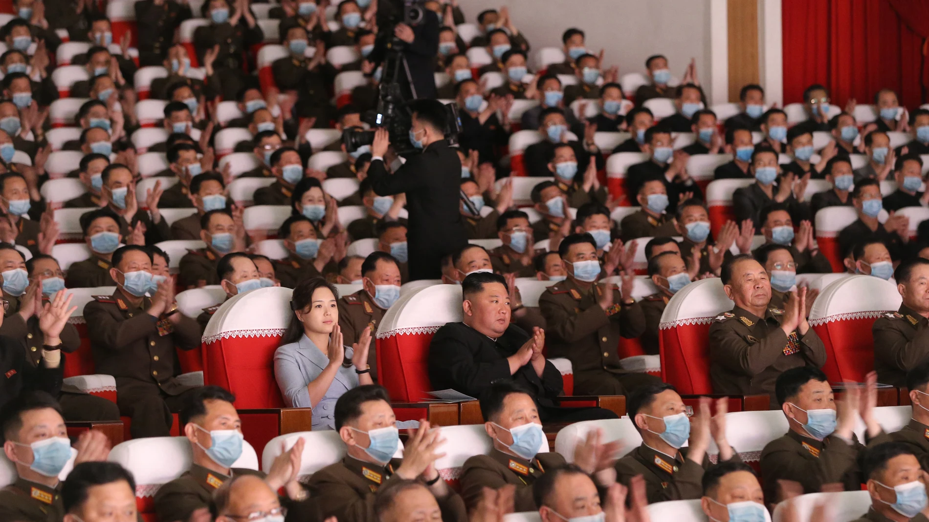 Kim Jong Un en el centro de la imagen sin mascarilla atiende un espectáculo junto a su mujer, también sin mascarilla, el pasado mes de mayo