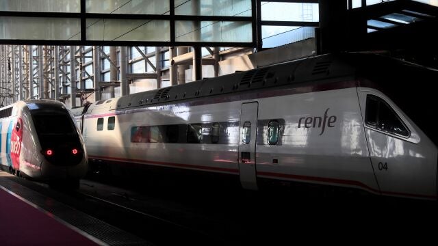 Uno de los trenes de Ouigo, junto a otro de Renfe en la estación de Atocha