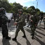 Soldados y policías prestan seguridad en medio de una manifestación de indígenas en Cali (Colombia).