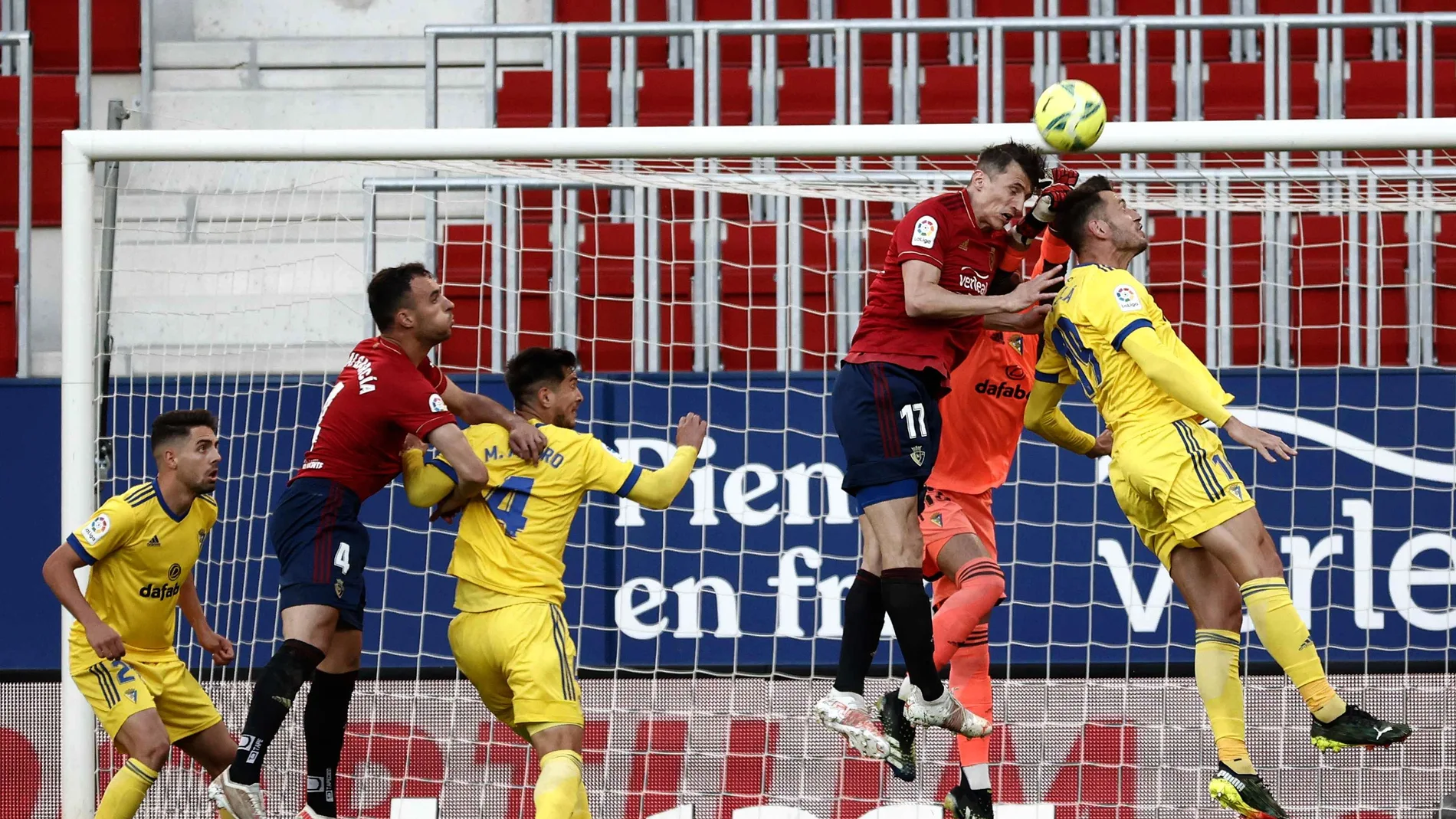El guardameta del Cádiz, David Gil (2d), despeja el balón ante su compañero, el defensa Pedro Alcalá (d) y el delantero croata de Osasuna, Ante Budimir
