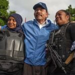 FILE - In this July 13, 2018 file photo, Nicaraguan police have their picture taken with President Daniel Ortega, after weeks of unrest in Masaya, Nicaragua. President Ortega is seeking a fourth consecutive term in November 2021, and he's pulling all the levers at his disposal to ensure his Sandinista National Liberation Front retains power. (AP Photo/Cristobal Venegas, File)