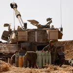 Soldados israelíes revisan proyectiles en un campo en Israel cerca de la frontera con Gaza