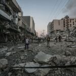 Ciudadanos inspeccionan las ruinas del derrumbe de la torre Al-Shorouk tras el impacto de un proyectil israelí