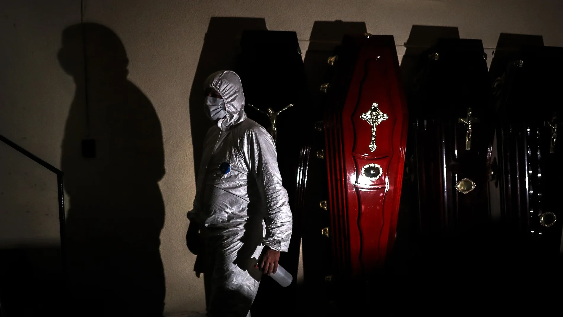 Un empleado de una funeraria desinfecta ataúdes en Buenos Aires
