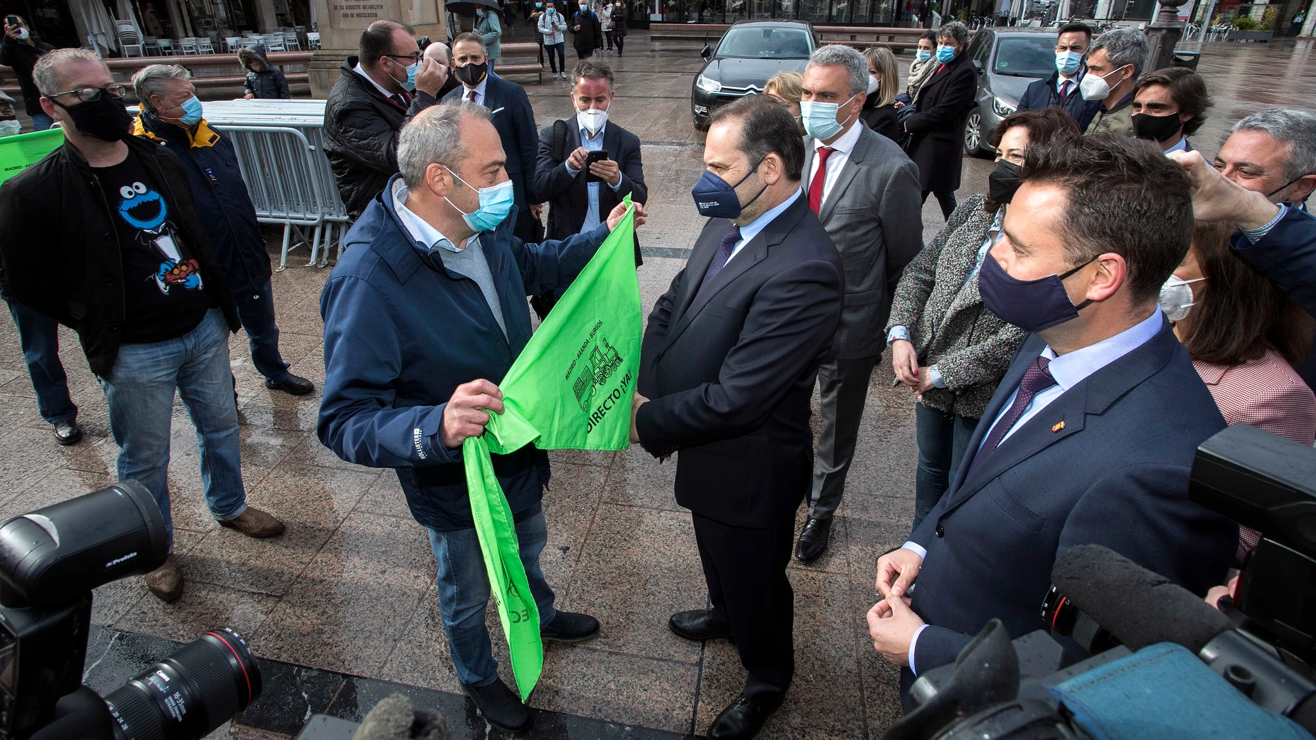 Un hombre ofrece al ministro de Transportes, Movilidad y Agenda Urbana, José Luis Ábalos (c) un pañuelo para pedir el tren directo, "Madrid-Burgos", línea que se encuentra cerrada actualmente