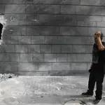 Un vecino de la localidad israelí de Ashkelon ante un muro dañado por un cohete lanzado desde Gaza