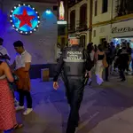 Un policía municipal de Sevilla, le recrimina a un joven que está esperando a la puerta de una discoteca que se coloque la mascarilla.Eduardo Briones / Europa Press