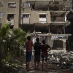 Vecinos de Ciudad de Gaza observan el balance de daños del bombardeo israelí en el que fallecieron diez miembros de la familia Abu Hatab Habibi, ayer