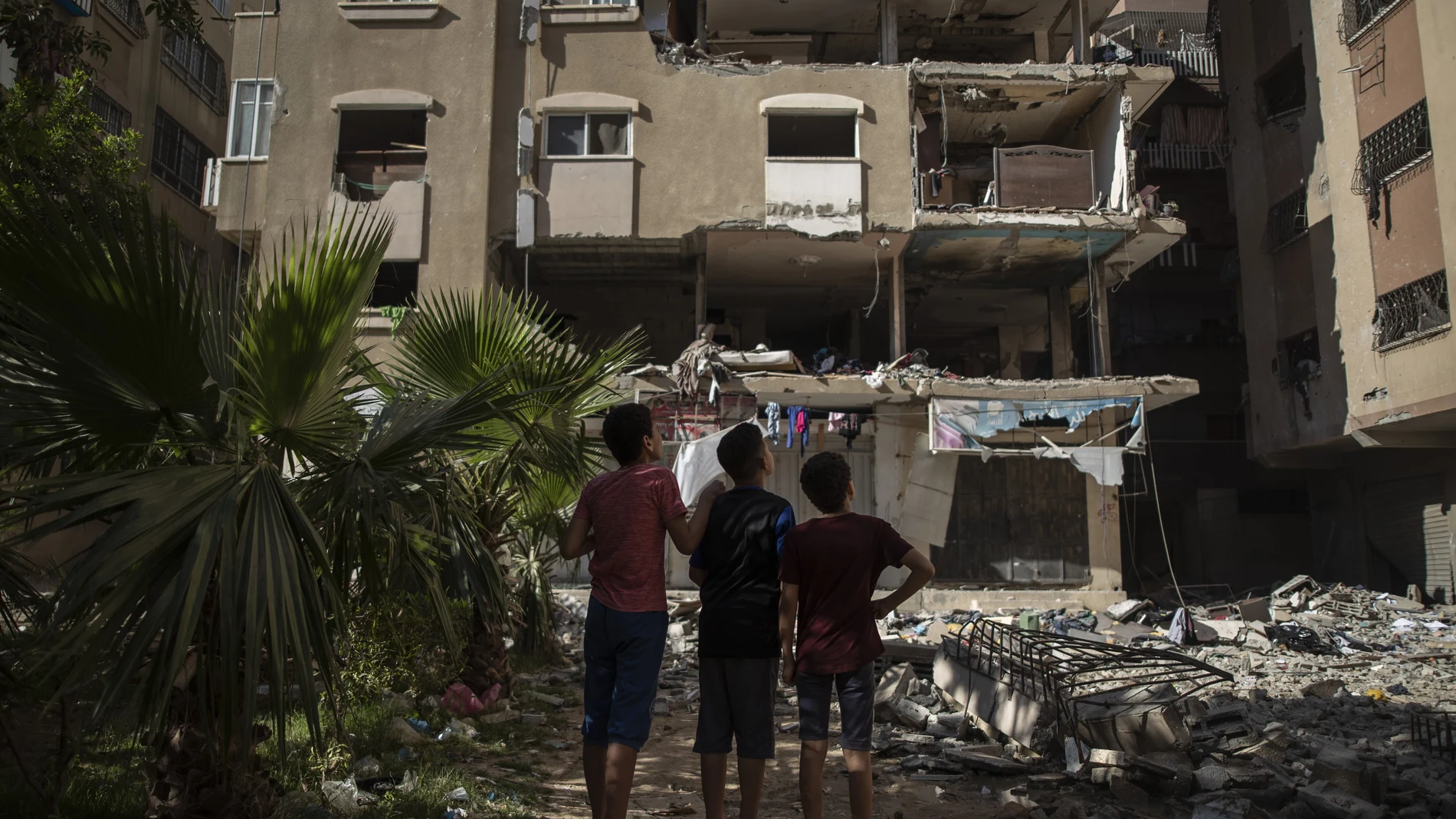 Vecinos de Ciudad de Gaza observan el balance de daños del bombardeo israelí en el que fallecieron diez miembros de la familia Abu Hatab Habibi, ayer
