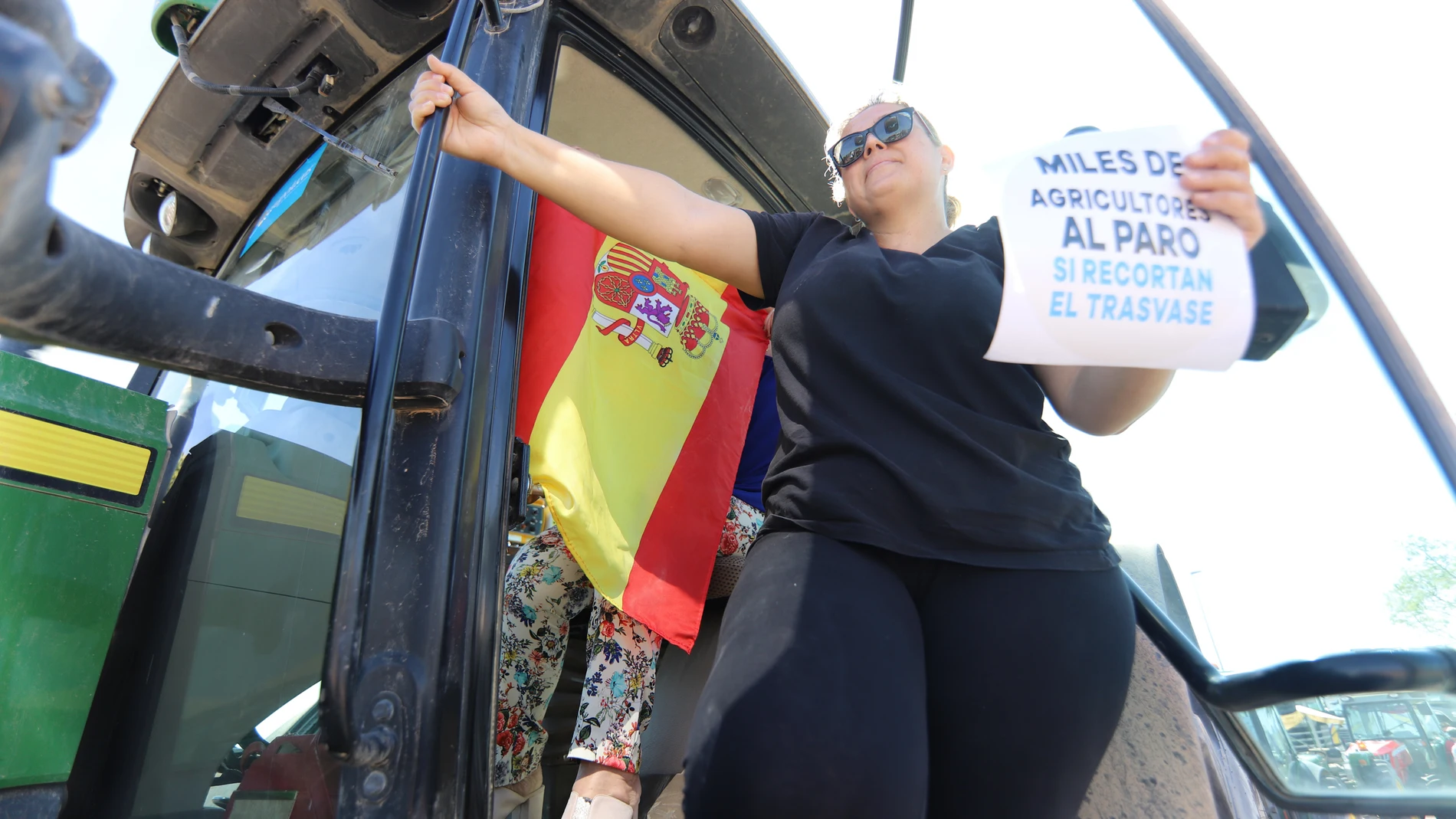 Una mujer sostiene un cartel desde su tractor en una tractorada en defensa del trasvase Tajo-Segura, a 15 de mayo de 2021, en Murcia