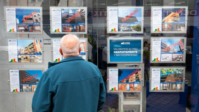 Una persona observa el escaparte de una agencia inmobiliaria en Madrid