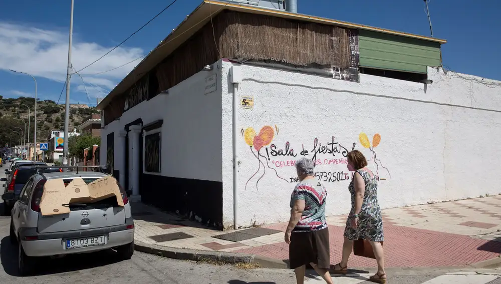 Unas mujeres caminan por la inmediaciones de un bar en la avenida Arroyo de los Ángeles, en la capital malagueña, donde la pasada madrugada se inició la reyerta