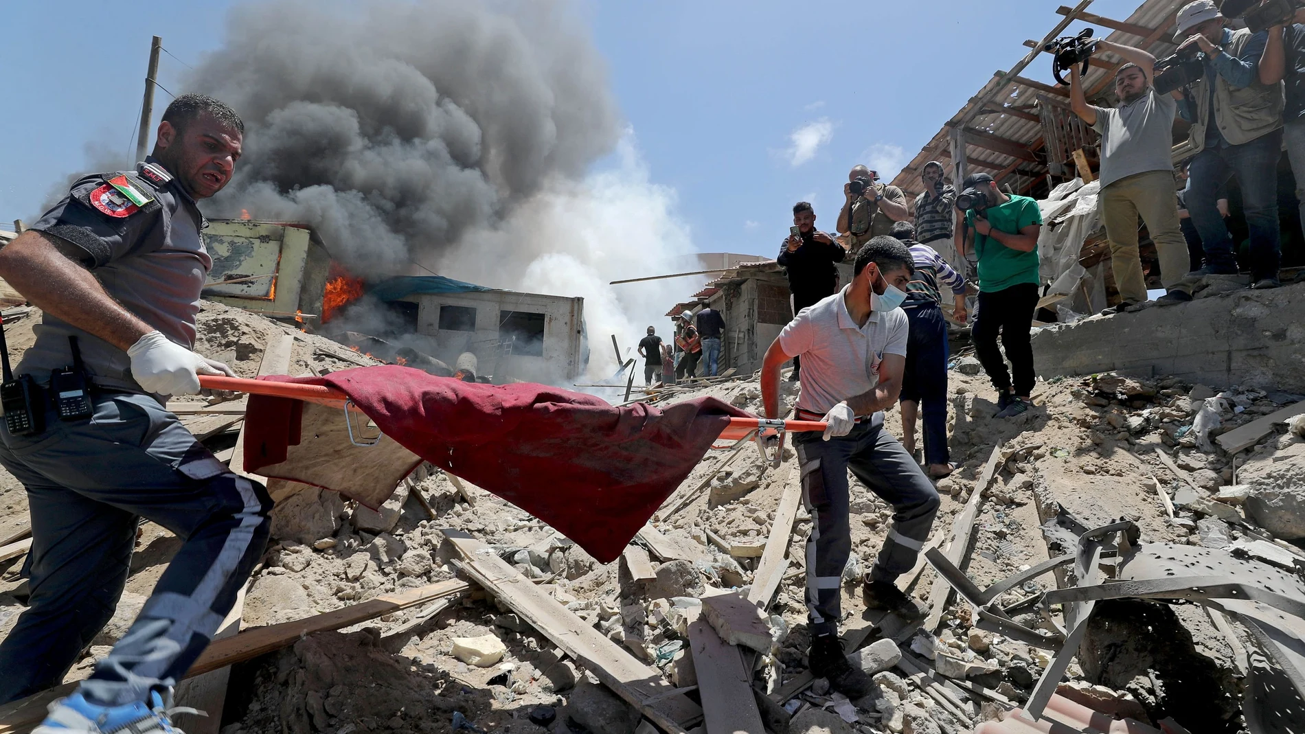 Palestinos evacuan un cadáver del lugar donde se produjeron los ataques israelíes en la ciudad de Gaza