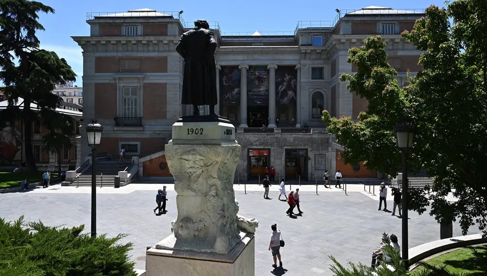 Goya observa a un grupo de personas desde lo alto de su pedestal delante del Museo del Prado
