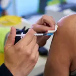 Un sanitario vacuna a una mujer con la dosis de Pfizer en el Wanda Metropolitano
