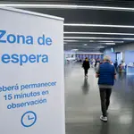 Un hombre entra en la zona de espera después de recibir la dosis con la vacuna de Pfizer en el Wanda Metropolitano de Madrid
