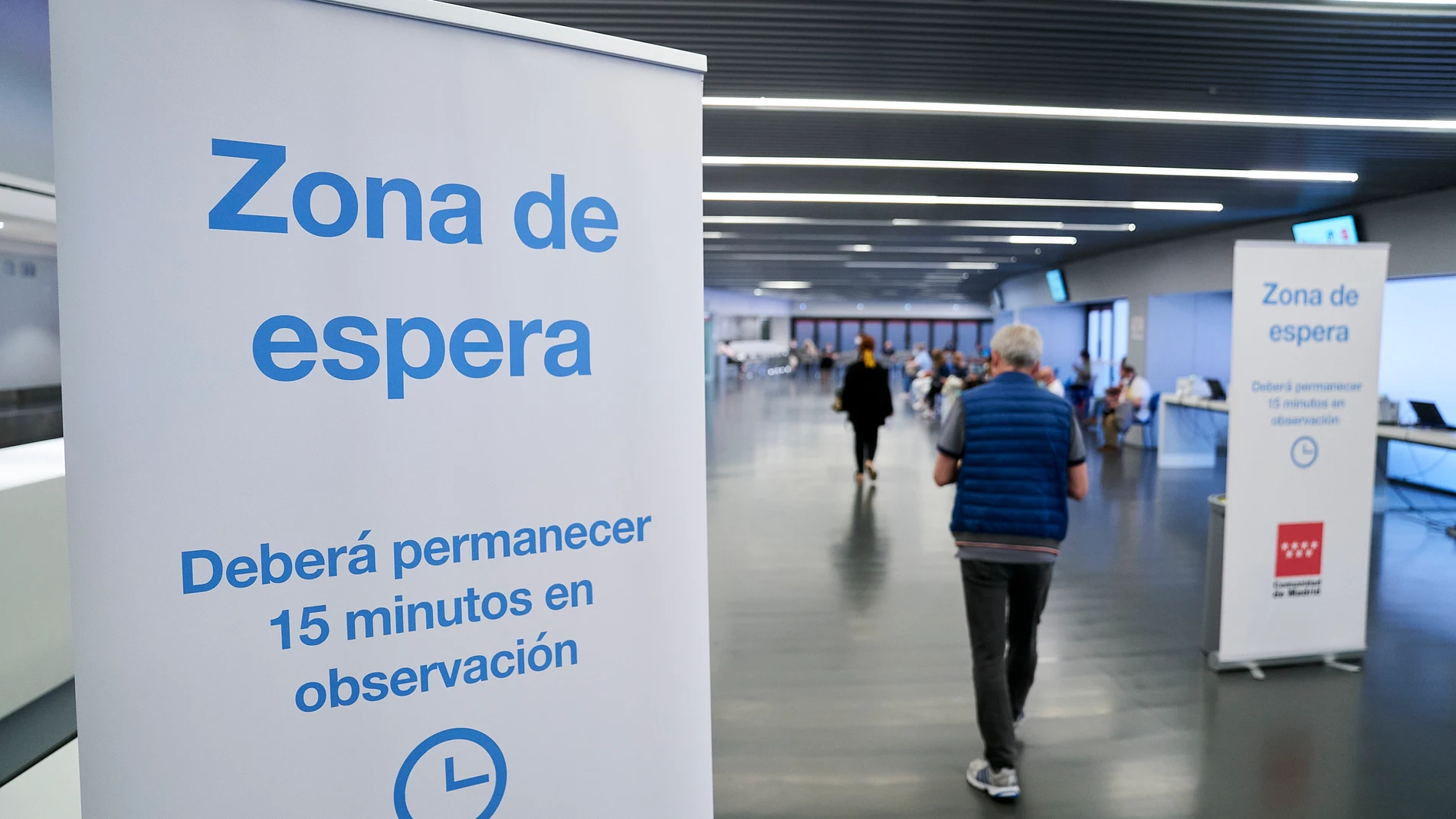 Un hombre entra en la zona de espera después de recibir la dosis con la vacuna de Pfizer en el Wanda Metropolitano de Madrid
