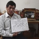 Edilberto Jimenez poses with one of his drawings at his home in San Juan de Lurigancho, on the outskirts of Lima, Peru, Thursday, May 20, 2021. Jimenez compiled in a book his interpretation of the sufferings that Peruvians have endured during the COVID pandemic that has caused a deepening economic crisis and has killed more than 66,000 people in the Andean country. (AP Photo/Martin Mejia)