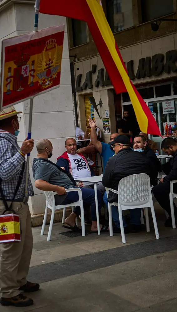 Un grupo de marroquíes y un hombre con una bandera de España, discuten en el centro de Ceuta