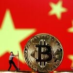 FILE PHOTO: Small toy figurines are seen on representations of the Bitcoin virtual currency displayed in front of an image of China's flag in this illustration picture, April 9, 2019. REUTERS/Dado Ruvic/Illustration/File Photo